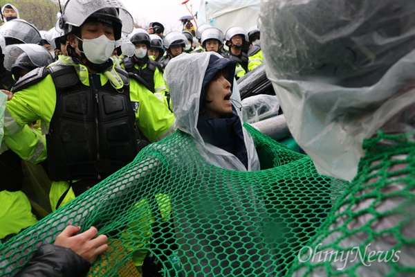 사드가 배치된 경북 성주군 소성리 진밭교 앞에서 공사장비 반입에 반대하는 주민을 경찰이 23일 오전 끌어내려 하자 파이프로 팔과 팔을 연결한 주민이 강하게 반발하고 있다.