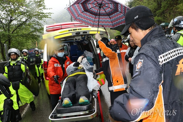 23일 사드기지가 설치된 경북 성주군 소성리 진밭교 앞에서 한 주민이 경찰의 진압에 맞서다 다쳐 119구급차로 실려나가고 있다.