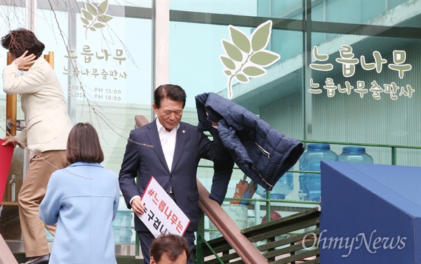 자유한국당 김한표 의원 등이 24일 오전 경기 파주시 느릅나무 출판사 앞에서 '#느릅나무는 누구겁니까'라고 적은 피켓을 들고 기념촬영을 마친뒤 내려서고 있다.