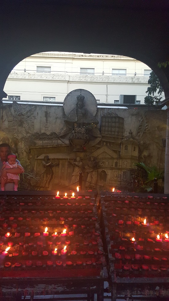 아기예수상 앞 붉은 촛불들을 바라보는 아버지와 아가의 모습도 경건하다