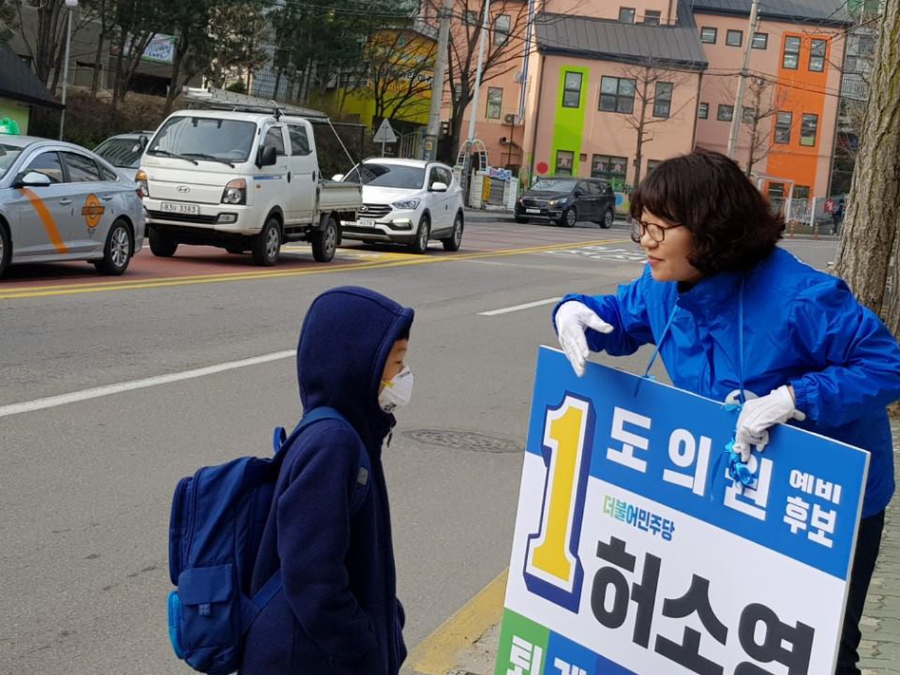  길거리 인사 도중 초등학생이 호기심을 보이며 다가오자 도의원의 역할에 대해서 소개해주고 있다