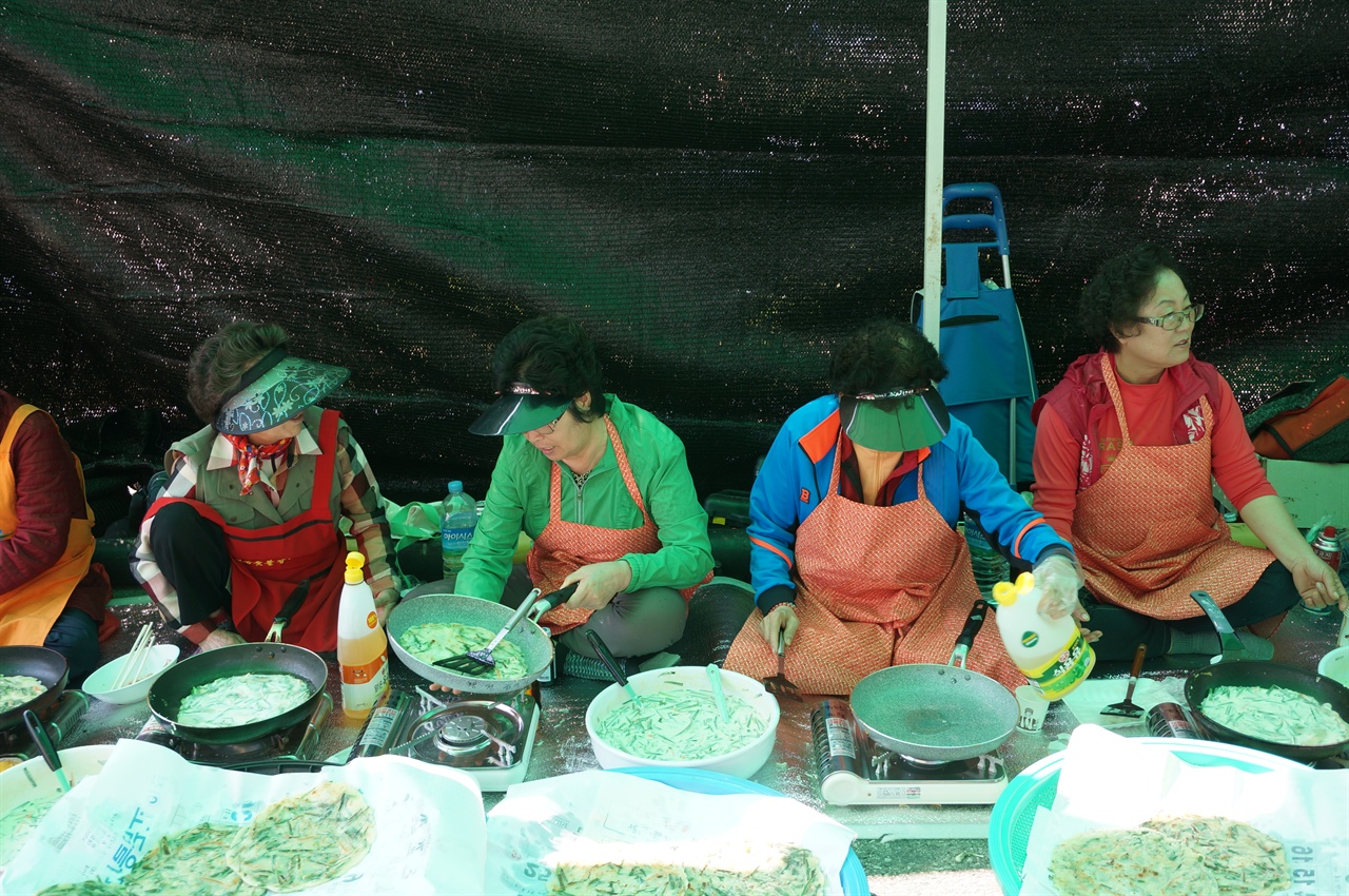 창전동 주민들이 창전동주민센터 마당에서 즐거운 이야기를 나누며 부침개를 굽고 있다. 