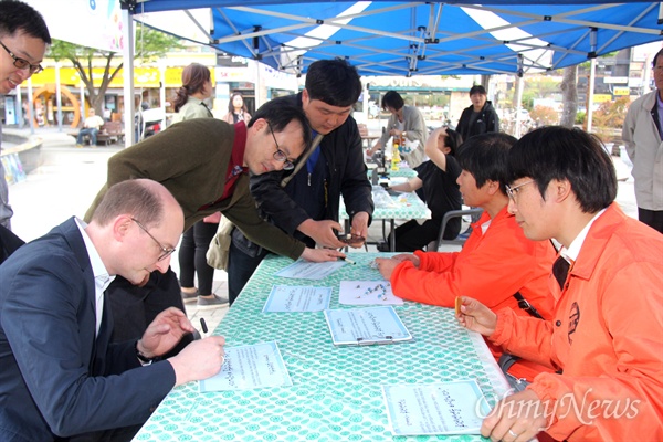 시민들이 25일 오후 창원 상남동 분수광장에서 열린 "남북정상회담 환영 문화제"에서 '종전선언'에 서명하고 있다.