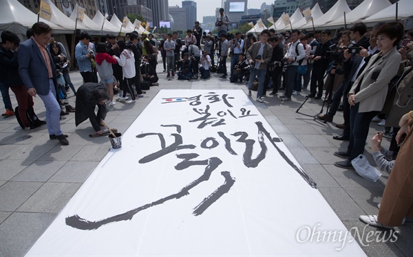 캘리그라피스트 강병인 작가가 26일 오후 서울 광화문 광장에서 남북정상회담 성공을 기원 하는 대형 붓글씨를 쓰고 있다.