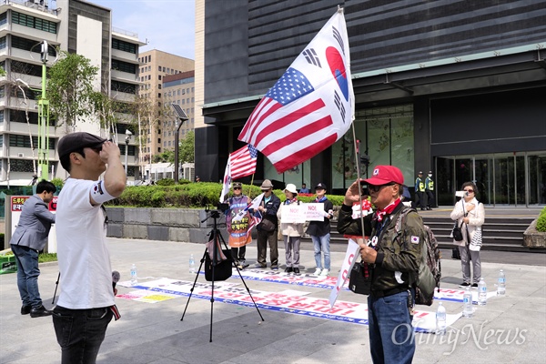 26일 오후 2시께부터 kt 광화문지사 앞에서 '비핵화 없는 평화 협정 반대! 종전 협정 반대!' 집회가 열렸다. 한 참가자가 태극기와 성조기를 이어붙인 깃발에 거수경례를 하고 있다.
