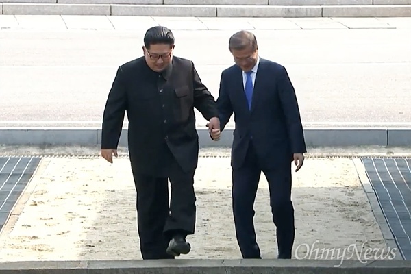  ‘2018남북정상회담’이 열리는 4월 27일 오전 문재인 대통령과 김정은 국무위원장이 판문점에서 만났다. 문재인 대통령과 김정은 국무위원장이 손을 잡고 군사분계선을 넘고 있다.