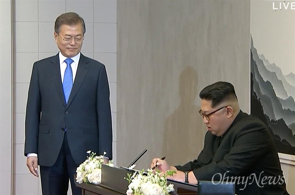 ‘2018남북정상회담’이 열리는 27일 오전 문재인 대통령과 김정은 국무위원장이 판문점에서 만났다. 김정은 국무위원장이 회담장인 남측 평화의 집에 도착해 방명록을 작성하고 있다.