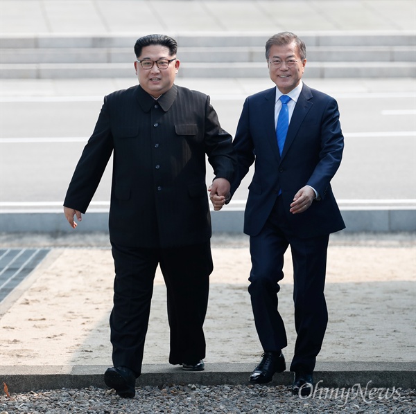 2018 남북정상회담이 열린 27일 오전 문재인 대통령과 김정은 국무위원장이 손을 잡고 군사분계선(MDL)을 넘어오고 있다.