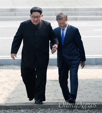 2018 남북정상회담이 열린 27일 오전 문재인 대통령과 김정은 국무위원장이 손을 잡고 군사분계선(MDL)을 넘어오고 있다.