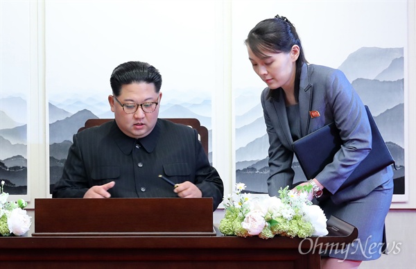 지난 2018 남북정상회담 당시, 문재인 대통령이 지켜보는 가운데, 김정은 국무위원장이 방명록을 작성하고 있다. 김 위원장 동생인 김여정 부부장(오른쪽)이 준비해온 펜을 전달하고 있다.