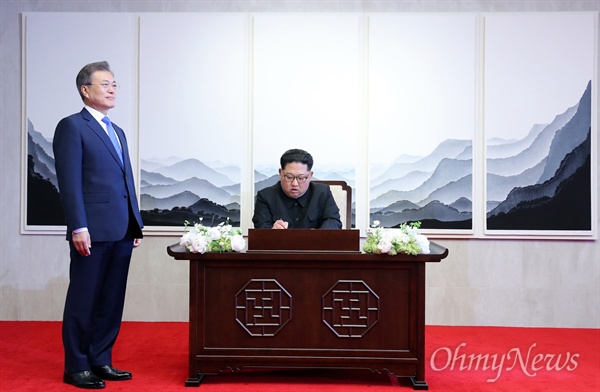 2018 남북정상회담이 열린 27일 오전 판문점 평화의 집에서 문재인 대통령이 지켜보는 가운데, 김정은 국무위원장이 방명록을 작성하고 있다.