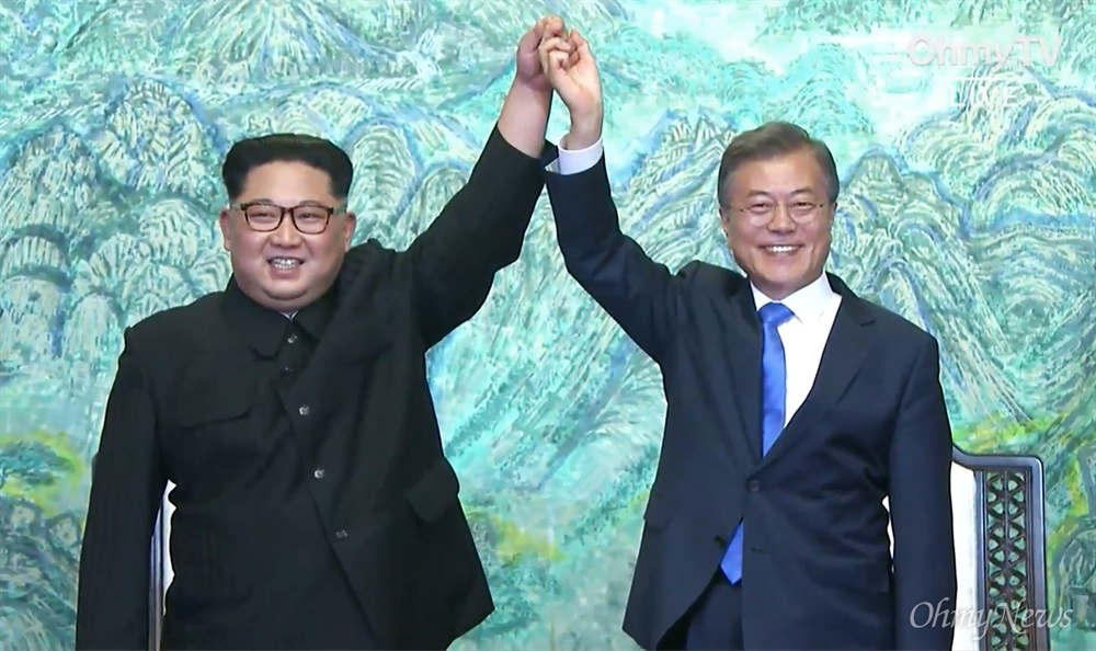 2018 남북정상회담이 열린 4월 27일, 판문점 남측 평화의 집에서 문재인 대통령과 김정은 국무위원장이 '판문점 선언'에 서명하고 발표했다. 서명 후 두 정상이 잡은 손을 들고 있다.