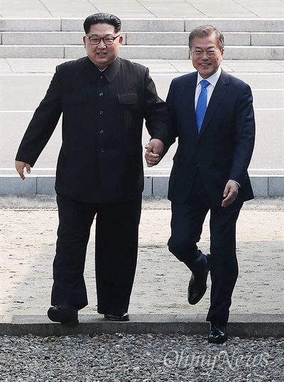 2018남북정상회담이 열리는 27일 오전 문재인 대통령과 김정은 국무위원장이 판문점 군사분계선을 손을 잡고 건너고 있다.