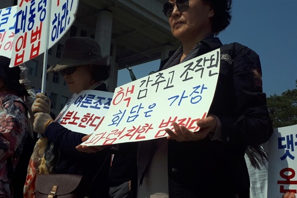 한 자유한국당 지지자가 29일 댓글조작 규탄 및 특검 촉구대회에 참석해 손팻말을 들고 있다. 