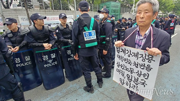  일제강제징용노동자상을 일본영사관 앞 위안부 평화의 소녀상 옆에 세우겠다는 계획이 경찰의 저지로 무산됐다. 1일 오후 노동자상 건립대회에서 한 시민이 강제징용에 대한 일본의 책임을 촉구하는 피켓을 목에 건 채 걷고 있다. 
