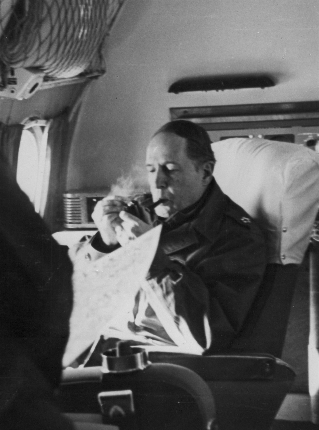 1950. 11. 24. 신의주 상공 비행기 안에서 파이프를 문 채 지도를 펴 보며 작전 구상을 하는 맥아더 장군.