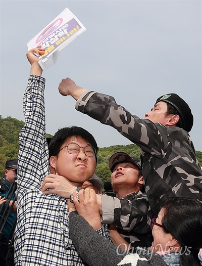  탈북자단체 회원들이 '전단장사꾼 박상학 이 땅을 떠나라'가 적힌 피켓을 뺏기 위해 몸싸움을 벌이고 있다.