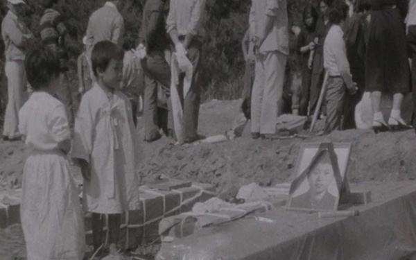 영상의 마지막 부분엔 망월동에 5·18 희생자들이 안장되는 장면이 나온다. 묘지 옆 햐안 상복을 입고 서있는 아이들의 모습.