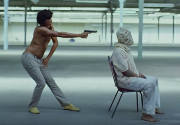  'This Is America'의 뮤직비디오 초반부 한 장면. 부자연스러운 차일디시 감비노의 동작에 대해 19세기 인종 차별의 상징적인 캐릭터 짐 크로(Jim Crow)를 은유했다는 주장이 있다.