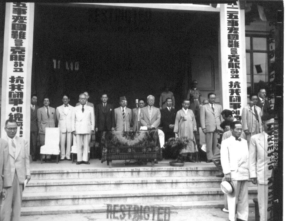  1951. 6. 25. 부산, 정부 3부 요인들이 6.25 1주년 기념식장에서 한국전쟁 전몰장병에게 묵념을 드리고 있다(단상 앞 열에는 왼쪽부터 신익희 국회의장, 이승만 대통령, 김병로 대법원장, 장면 국무총리 등이 서 있다).