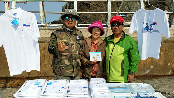 몇년전 독도에 상륙한 관광객들에게 독도기념품을 팔고 있는 김성도씨 부부와 정광태(맨 왼쪽) 가수. 정광태씨는 <독도는 우리땅>을 부른 가수다