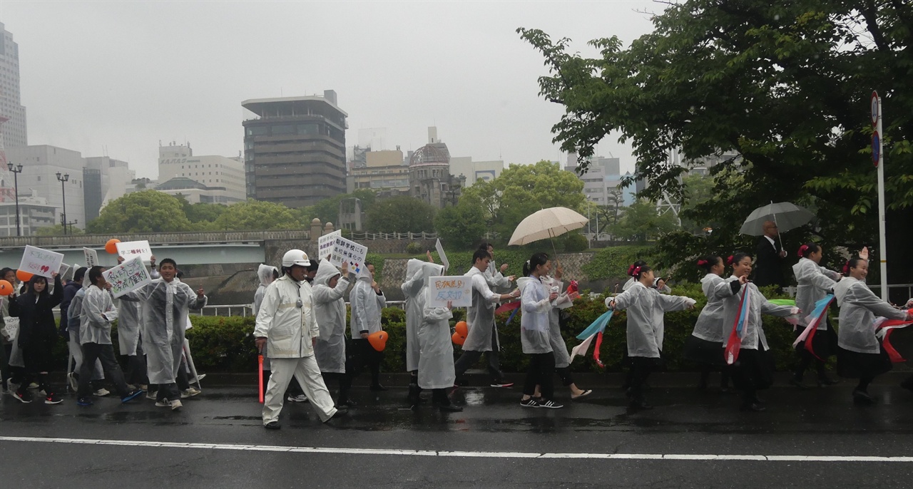 평화집회 참가자들이 히로시마의 상징인 원폭돔을 지나고 있다