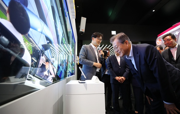 문재인 대통령이 17일 오후 서울 강서구 마곡 R&D 단지에서 열린 혁신성장 보고대회에서 SKT관계자로부터 설명을 들으며 5G를 이용한 스마트 미디어월을 체험하고 있다. 