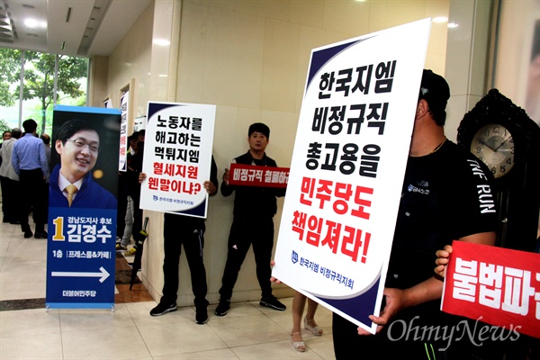 더불어민주당 김경수 경남지사 후보 선거사무소 개소식이 열린 17일 오후, 한국지엠 창원공장 비정규직들이 손팻말을 들고 서 있었다.