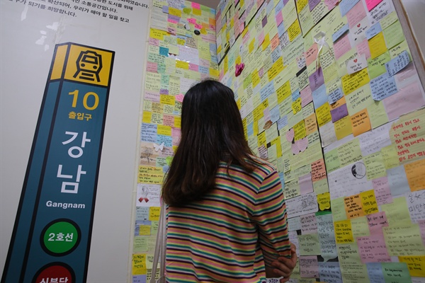 강남역 여성 살해사건 2주기를 맞은 지난 5월 17일 서울 동작구 여성플라자 성평등도서관 '여기' 안에 마련된 '기억ZONE:강남역 10번 출구'를 찾은 한 여성이 포스트잇 글들을 읽으며 피해여성을 추모하고 있다. 