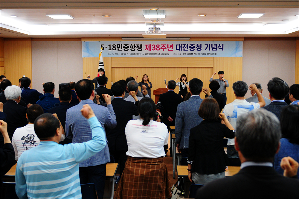 기념식 참가자들은 ‘임을 위한 행진곡’을 함께 제창하고 있다. 무대에 올라 대전청년회 노래모임 ‘놀’이 함께 부르고 있다.