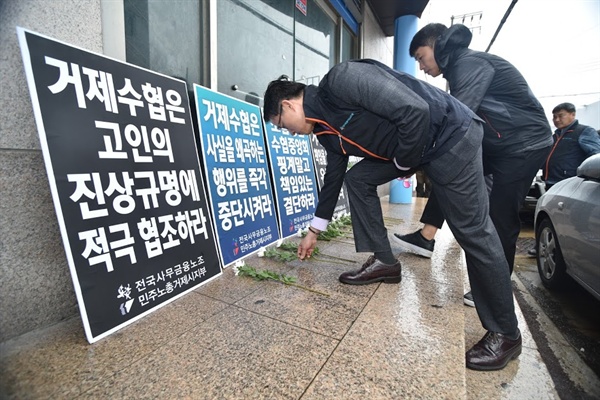  전국사무금융서비스노동조합 부산울산경남지역본부 조합원들이 직원 사망사고가 발생한 거제수협 앞에 국화꽃을 놓고 있다. 