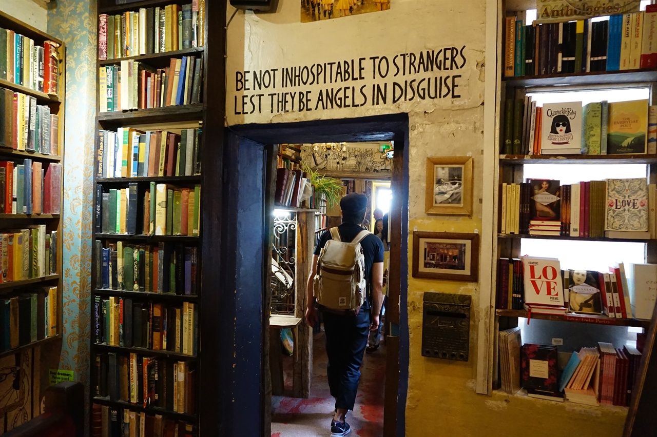 서점 안 통로 벽 위에 쓰인 표어는 "낯선 이를 홀대하지 마라, 그들은 변장한 천사들일지도 모르니(Be not inhospitable to strangers, lest they be angels in disguise)"라는 내용이었다. 
