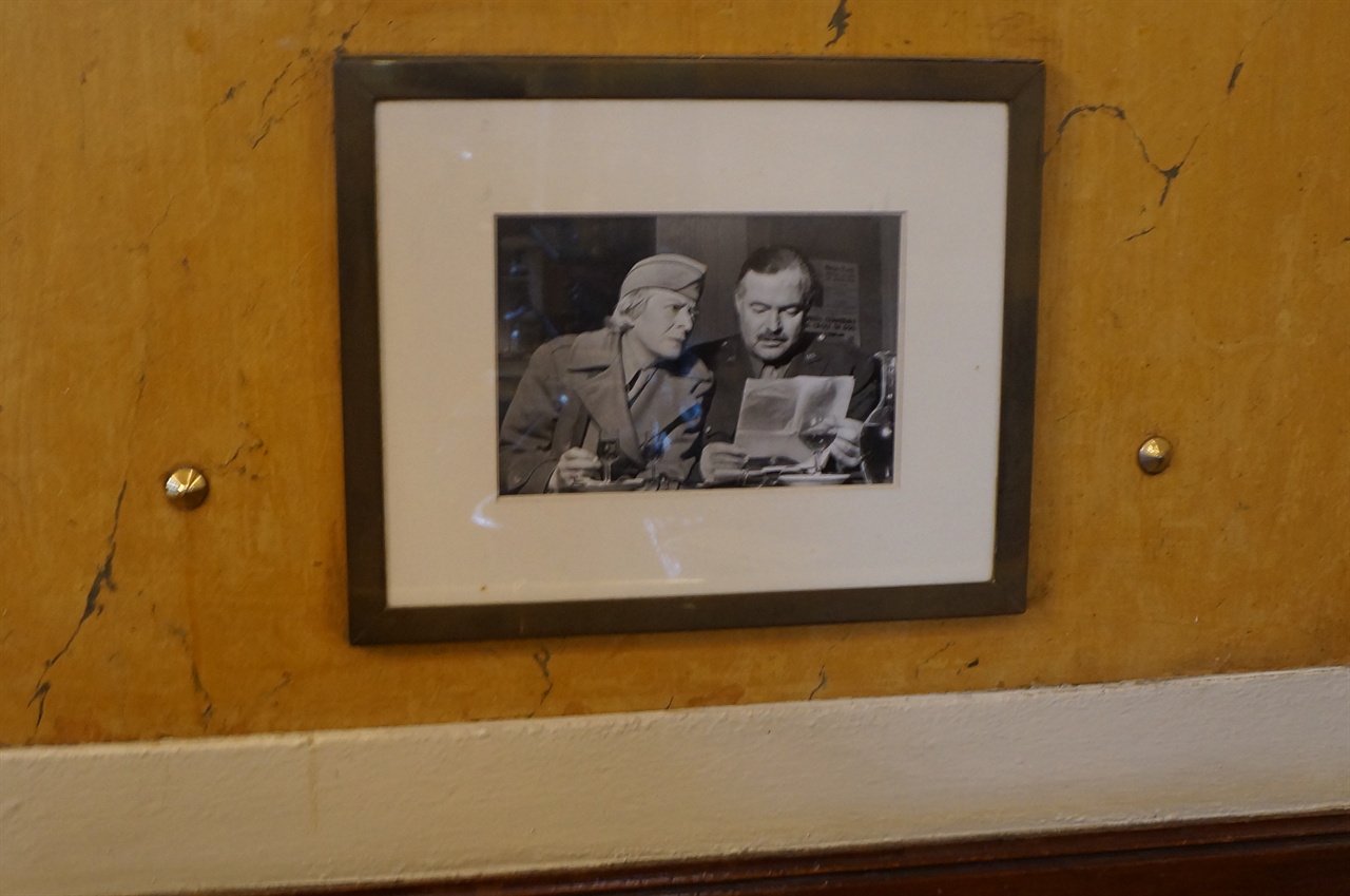 카페 레 되 마고 안의 오른쪽 좌석 위에 걸린 헤밍웨이의 사진 액자.