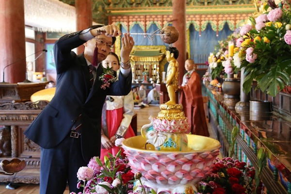 더불어민주당 김경수 경남지사 후보가 22일 해인사에서 열린 부처님오신날 봉축법요식에 참석해 관불의식을 하고 있다.