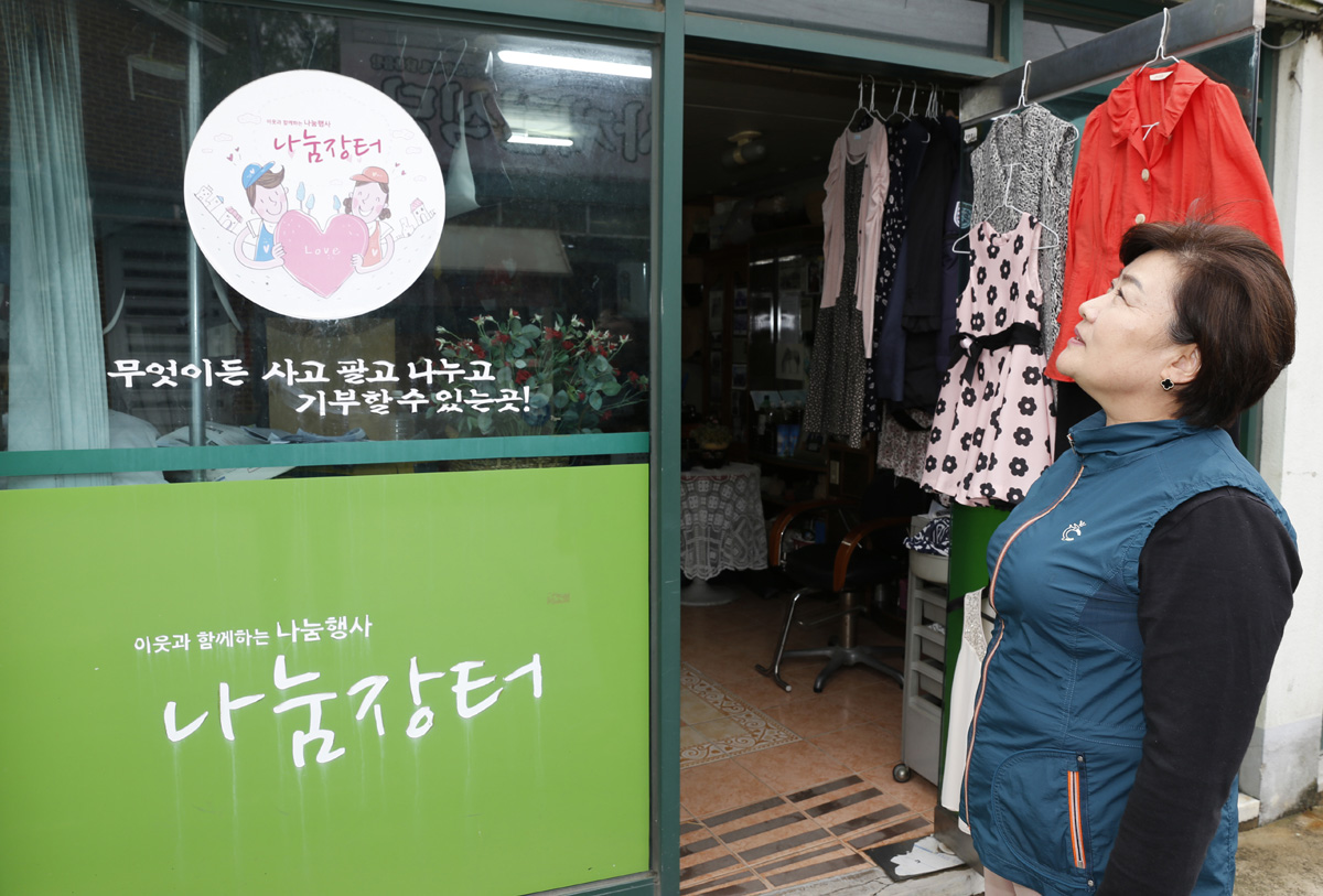 권창희 씨가 나눔장터 스티커를 바라보고 있다. 그녀는 6년 전 폐업한 미장원 자리를 아예 나눔장터로 만들었다. 