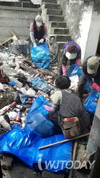 지난 11일 A 끼 집에서 쓰레기를 치우고 있는 단구동 행정복지센터 직원들과 자원봉사자들.