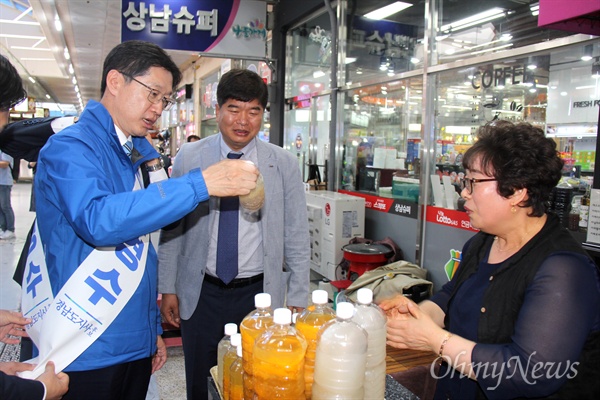 더불어민주당 김경수 경남지사 후보는 25일 오후 창원 상남시장을 찾아 한 가게에서 식혜를 사고 있다.