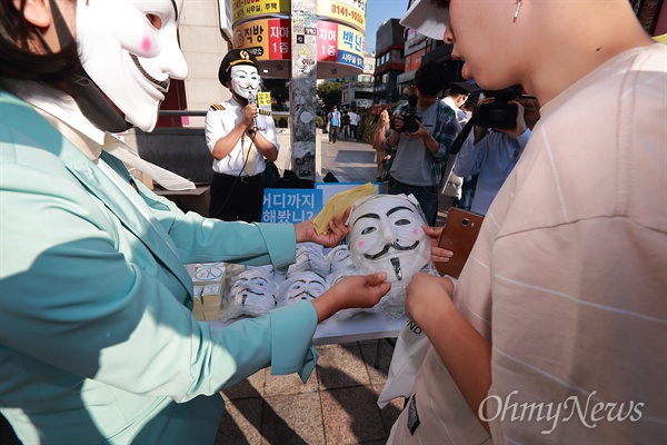 대한항공직원연대, '갑질 근절' 게릴라 홍보 대한항공직원연대 회원들이 1일 오후 서울 홍대입구역 부근에서 갑질근절 문화캠페인 게릴라 홍보를 하고 있다.  브이포벤데타 가면을 쓴 직원들이 갑질근절 스티커, 배지, 네임태그 등을 시민들에게 나눠줬다.