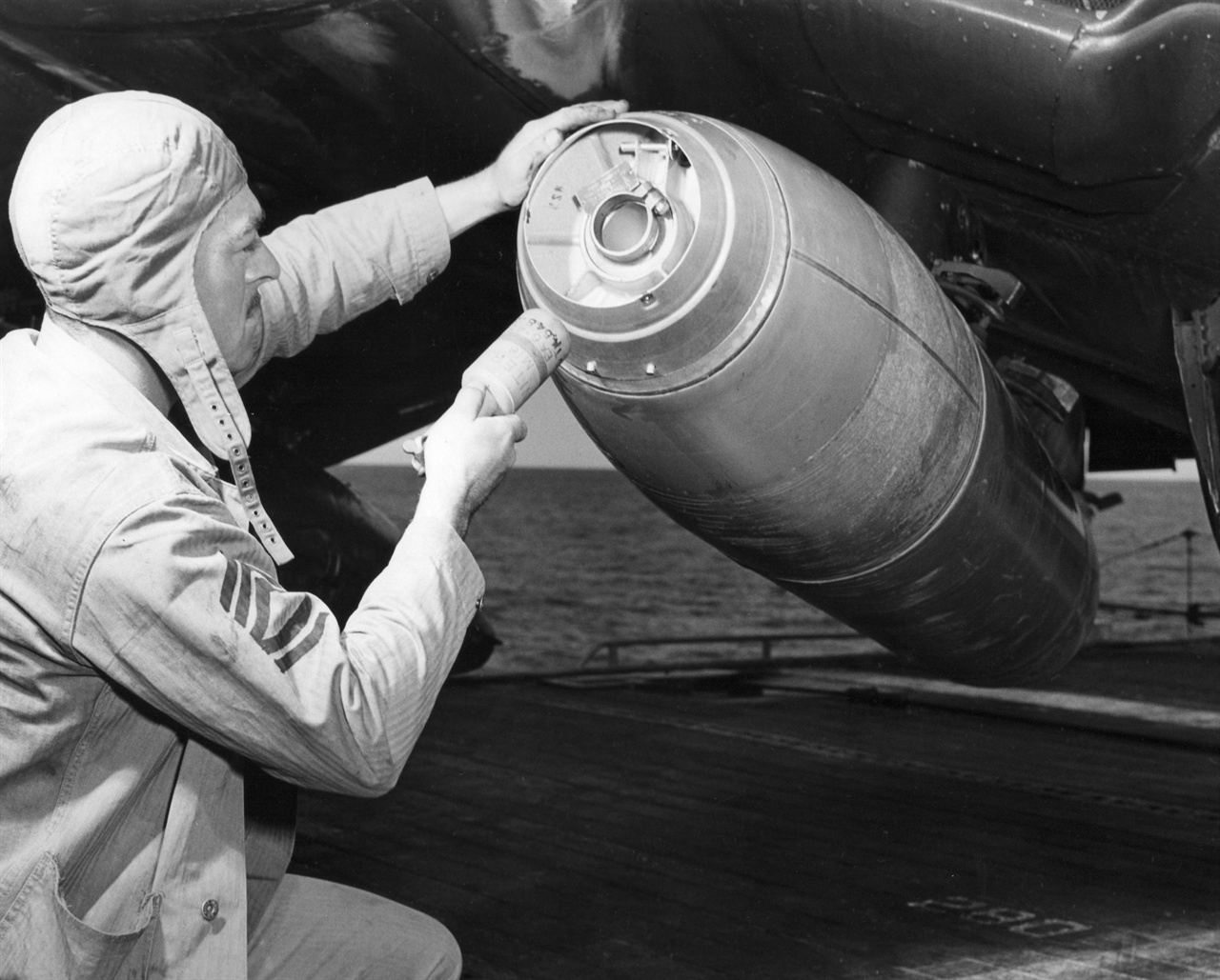 1951. 10. 28. 미 해군 하사관이 새로 개발한 네이팜탄을 전투기에 장전하고 있다.