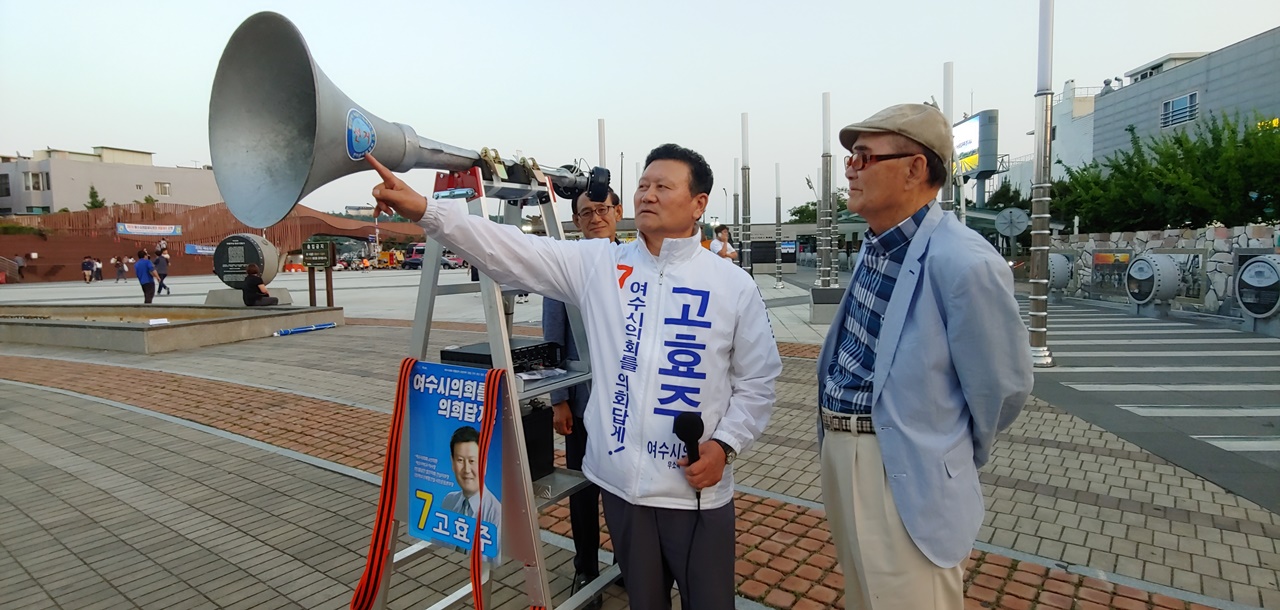 지나가던 행인에게 지게형 확성기를 설명하는 여수시라선거구 무소속 고효주 시의원의 모습