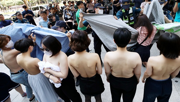 2일 오후 서울 강남구 페이스북코리아 앞에서 여성단체 '불꽃페미액션' 회원들이 페이스북의 성차별적 규정에 항의하는 상의 탈의 시위를 하고 있다. 이 단체는 앞서 페이스북이 남성의 반라 사진은 그대로 두면서 여성의 반라 사진만 삭제하는 점을 규탄하기 위해 기자회견을 열었다고 밝혔다.