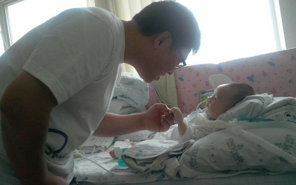 강현이가 병원에 온 아빠와 반갑게 인사하고 있다