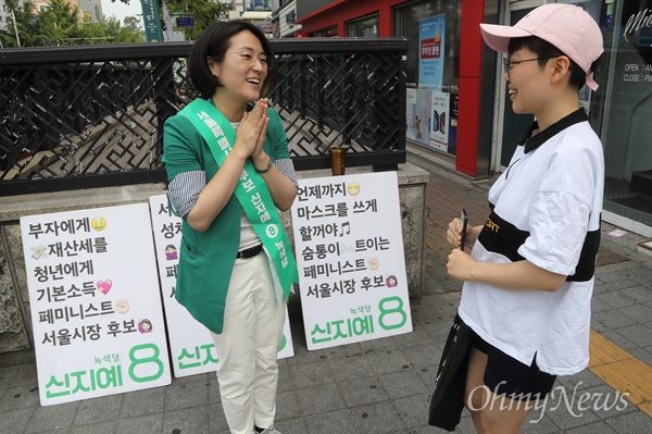  신지예 녹색당 서울시장 후보가 5일 오후 서울 성북구 안암역 앞에서 유권자와 인사를 나누며 지지를 호소하고 있다.