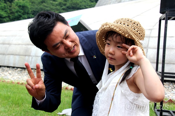 자유한국당 김태호 경남지사 후보가 6월 6일 오전 창원 충혼탑에서 열린 '제63회 현충일 추념식'에 참석한 뒤 한 아이와 사진을 찍고 있다.