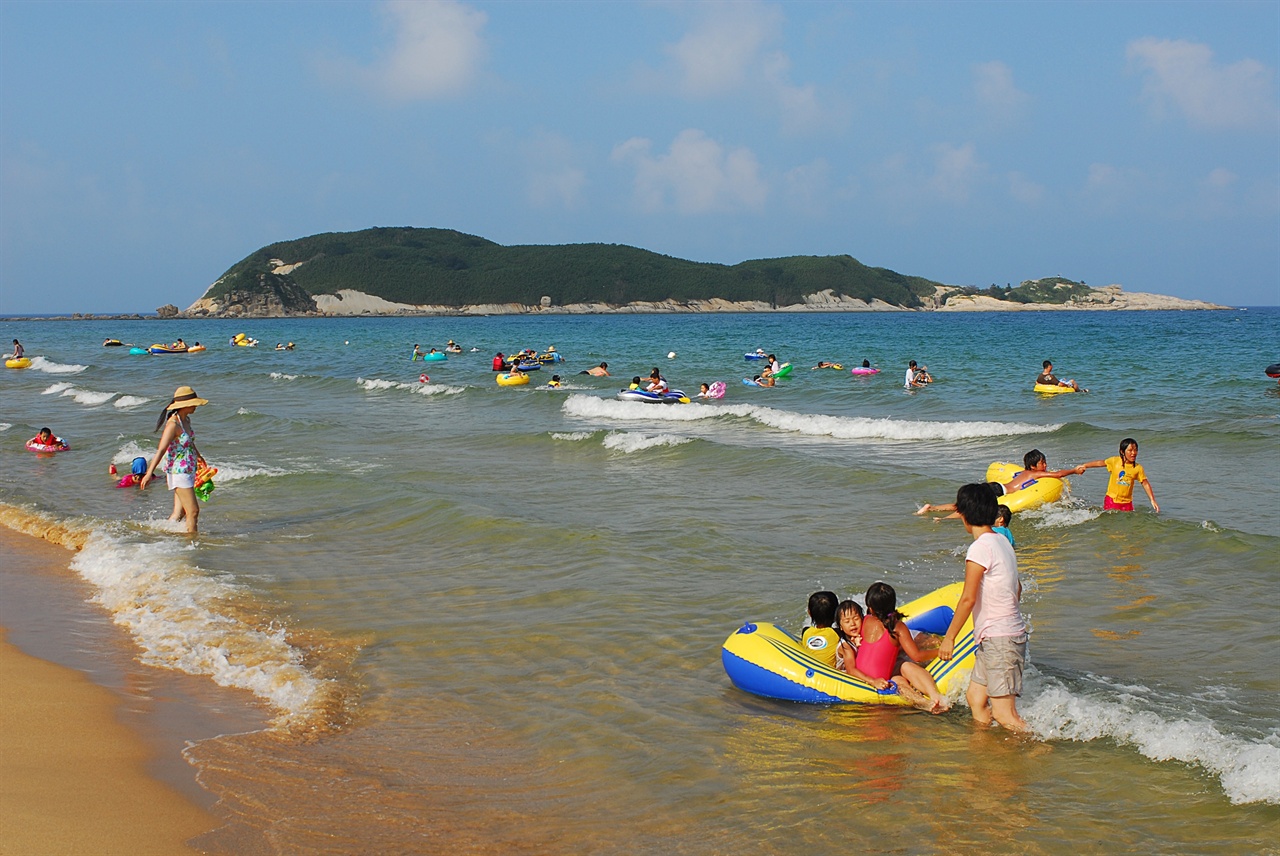 멀리 죽도를 바라보는 송지호 해변은 동해안에서 가장 얕은 바다에서 안전하게 물놀이를 즐길 수 있는 곳이다. 