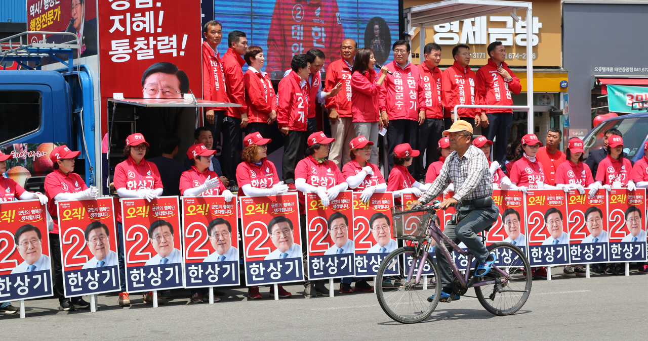 무심한 듯 유세장을 지나치는 유권자 사전투표를 하루 앞둔 7일 자유한국당은 9명의 전 후보자가 참가한 가운데 제3차 합동유세를 가졌다. 