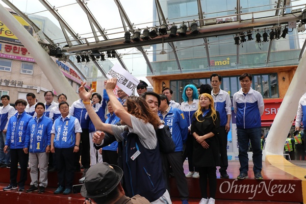  9일 오전 추미애 민주당 대표와 중앙당 선대위 관계자들이 대구지역 후보들을 지원하기 위해 대구시 중구 동성로 대구백화점 앞 무대에 올라 인사를 하는 가운데 민주노총 한 조합원이 앞으로 나와 '최저임금법 개악안 폐기'를 외치고 있다.