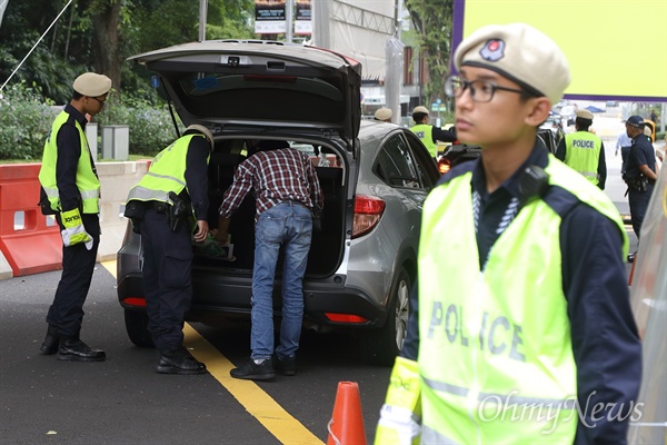 북미정상회담을 이틀 앞둔 10일 오전 김정은 북한 국무위원장의 숙소인 싱가포르 세인트 리지스 호텔 앞에서 경찰이 호텔 진입하는 차량의 검문검색을 하고 있다.