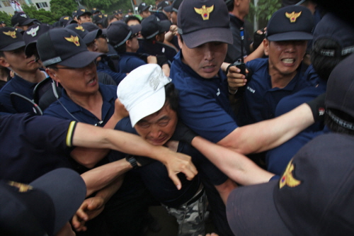 2012년 7월 제주해군기지 공사장 앞에서 공사에 반대하는 강정마을 주민을 경찰들이 진압하는 모습입니다. 