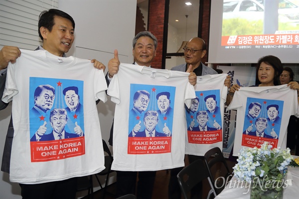 김정은 북한 국무위원장과 도널드 트럼프 미국 대통령의 역사적인 첫 북미정상회담이 이뤄진 12일 오전 싱가포르 한인회 사무실에서 교민들이 모여 두 정상의 성공적인 만남을 기원하며 제작된 티셔츠를 들어보이고 있다.